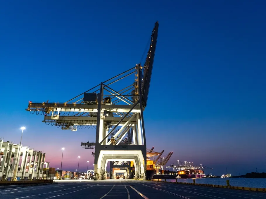 Portique à conteneurs la nuit : les paiements fournisseurs préparent les importations