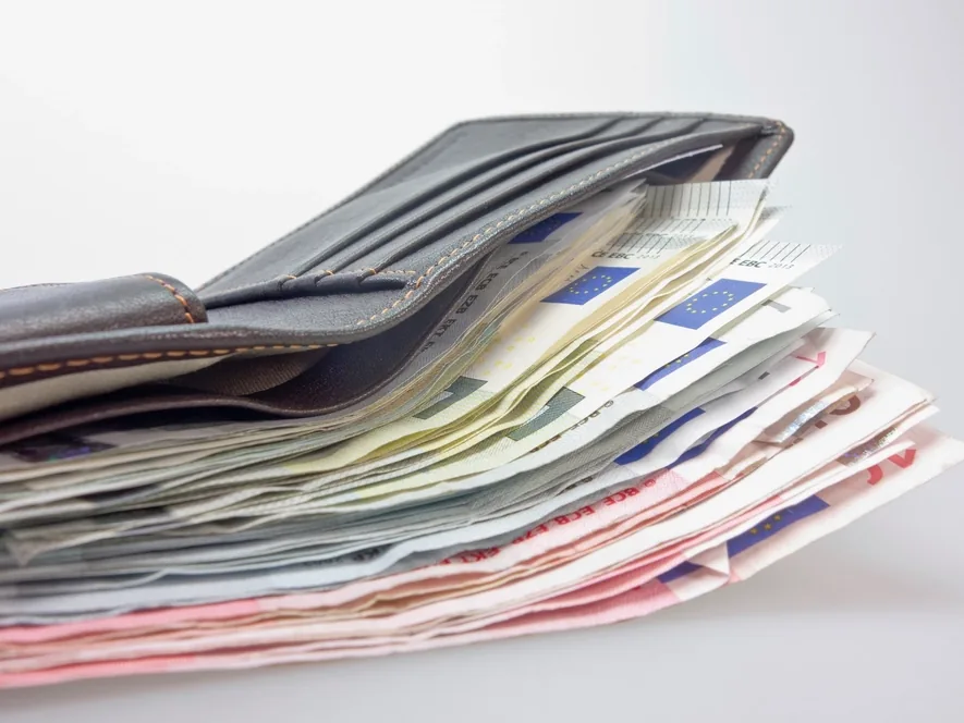 Portefeuille garni de billets : le retrait en espèces reste la forme de réception la plus demandée